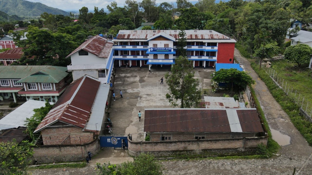 An elevated view of the T.L. Shalom Academy campus in Motbung, Manipur, surrounded by hills.