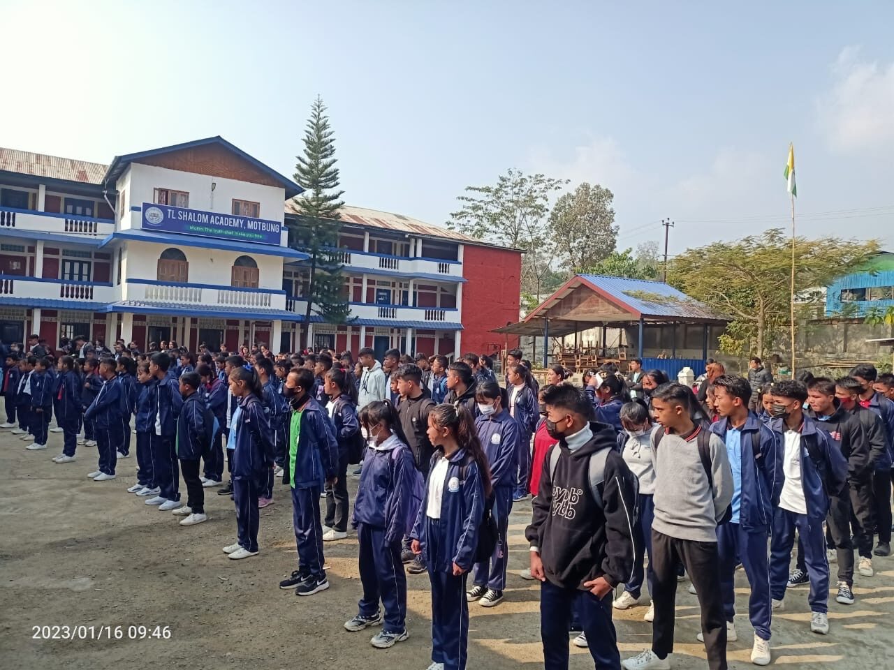 Students in navy uniforms lined up for morning assembly at the academy.