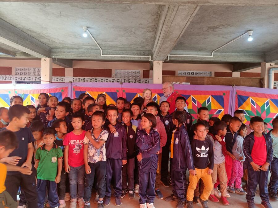 A large group of young children gathered under the campus pavilion.