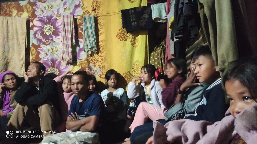 Women and children seated together during a house church service.