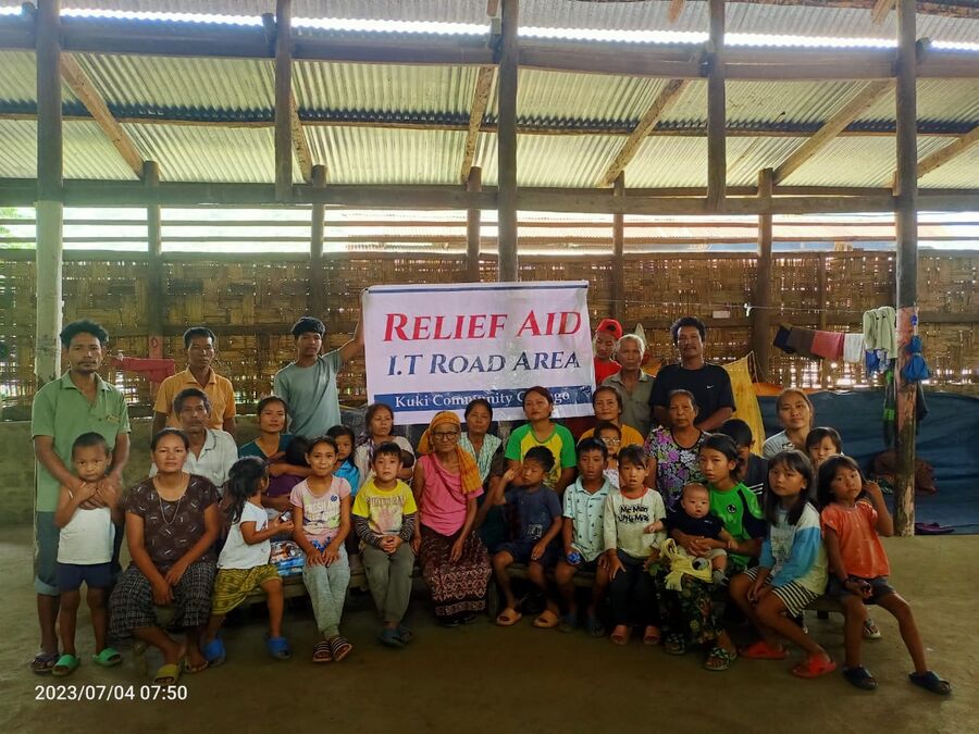 Children gathered beneath a Relief Aid banner during a distribution.