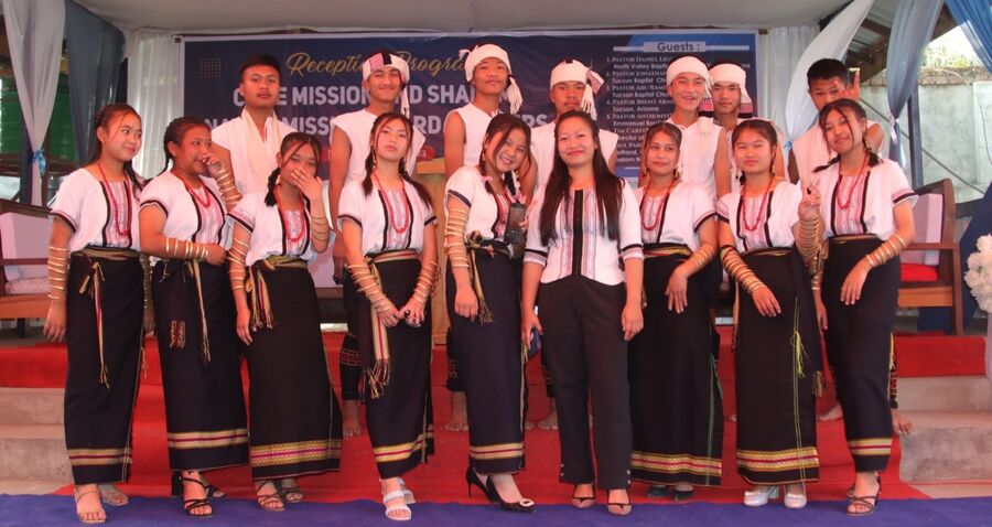 Students performing in traditional Kuki dress on stage at a mission conference.